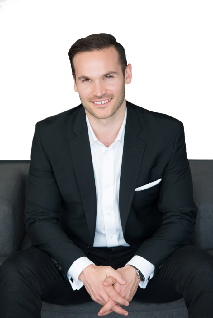 Leo Wilk, a top Vancouver Realtor, smiling in front of a Vancouver home